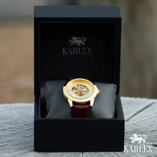 Guldfärgad Karlex-klocka med brunt läderarmband i en svart presentask