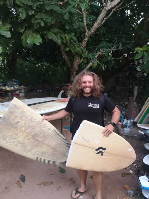 Alexis Piippo med två surfbrädor, varav en knäckt